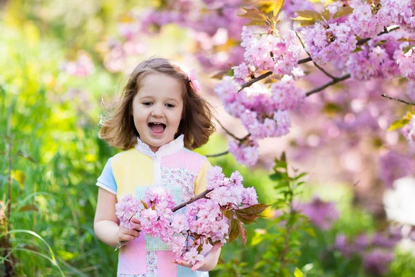 Liten flicka med körsbärsblommor — Stockfoto