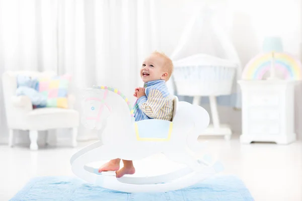 Baby boy in rocking horse toy