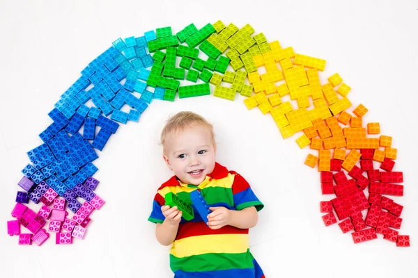 Criança brincando com arco-íris blocos de plástico brinquedo — Fotografia de Stock