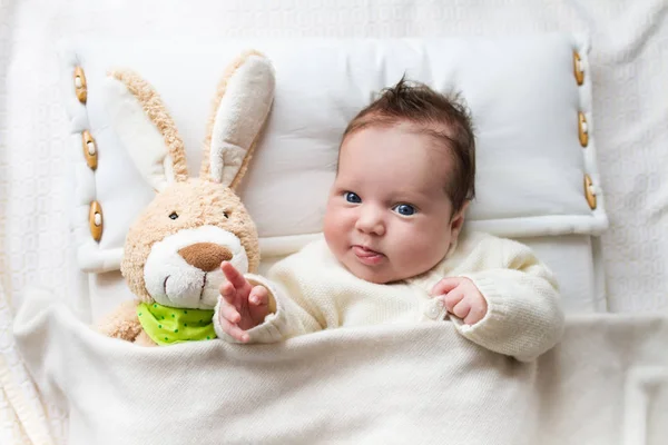 Bebê na cama com coelho brinquedo — Fotografia de Stock