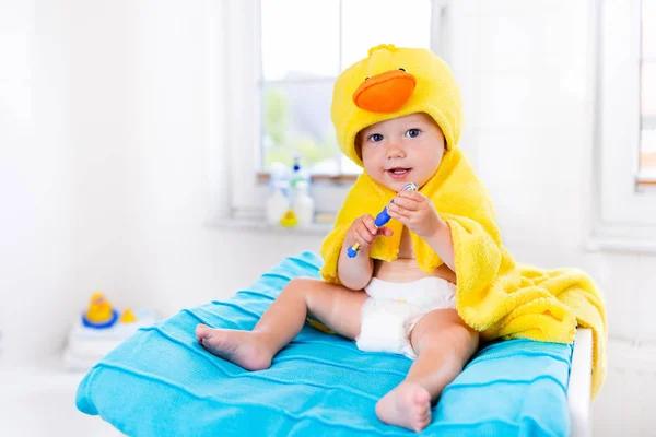 Baby in bath towel with tooth brush — Stock Photo, Image