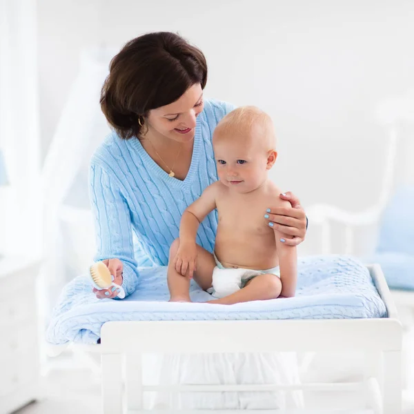 Mother changing diaper to baby boy