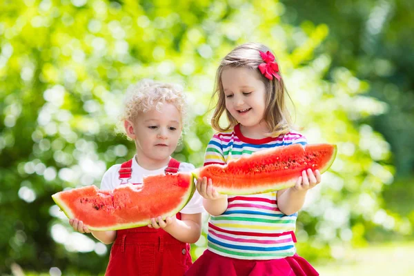 Crianças comendo melancia no jardim — Fotografia de Stock