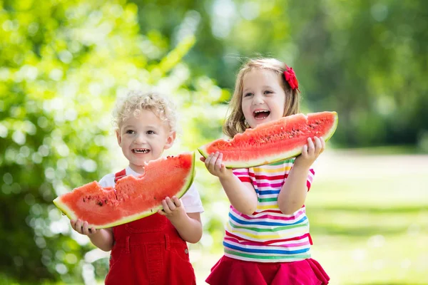 庭でスイカを食べる子供 — ストック写真