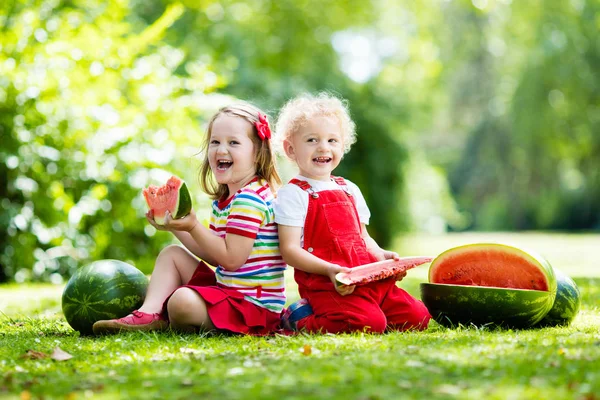 Dzieci jedzenie arbuza w ogrodzie — Zdjęcie stockowe