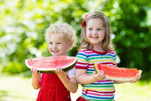 Crianças comendo melancia no jardim — Fotografia de Stock