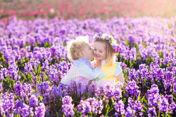 Kinderen spelen in de bloeiende tuin met bloemen van de hyacint — Stockfoto