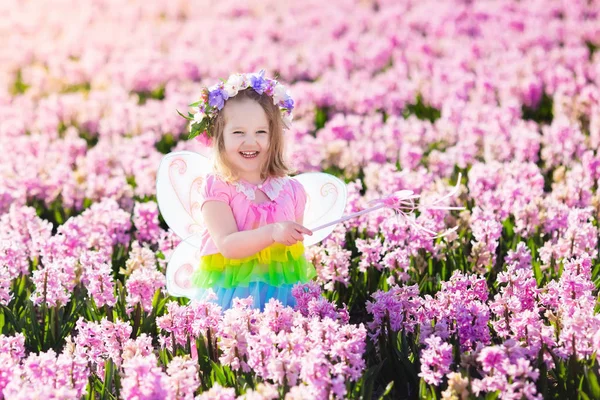 Little girl in fairy costume playing in flower field — Stock Photo, Image