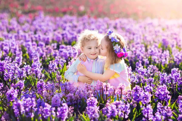 Kids playing in blooming garden with hyacinth flowers — Stock Photo, Image