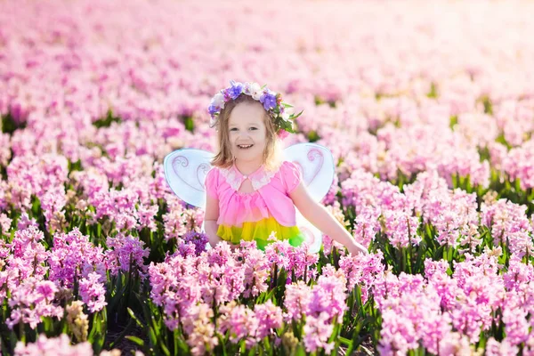 Niña en traje de hadas jugando en el campo de flores —  Fotos de Stock