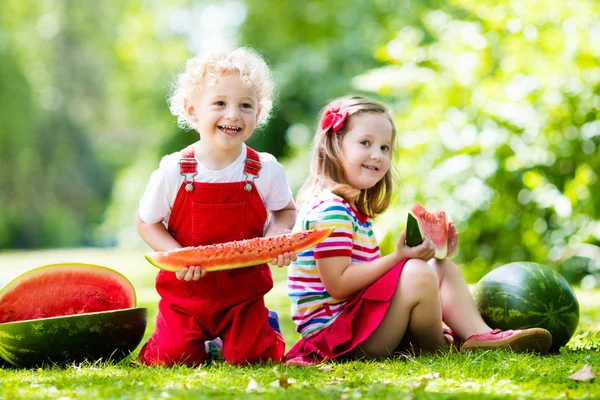 Barn som äter vattenmelon i trädgården — Stockfoto