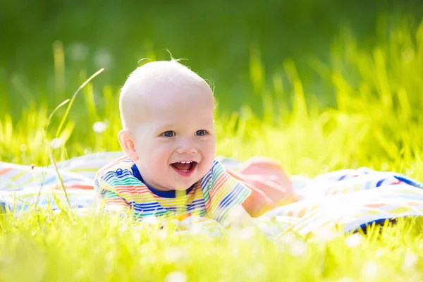 Baby boy with apple on family garden picnic — Stock Photo, Image