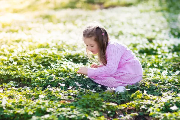 Kind in voorjaar park met bloemen — Stockfoto