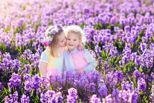 Дети играют в цветущем саду с гиацинтовыми цветами — стоковое фото