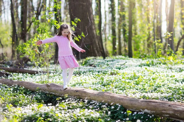 Niño en el parque de primavera con flores — Foto de Stock