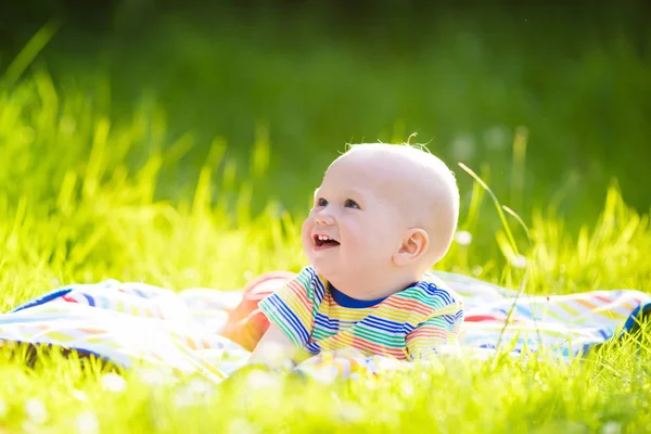 Baby boy with apple on family garden picnic — Stock Photo, Image