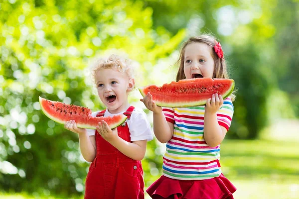 Dzieci jedzenie arbuza w ogrodzie — Zdjęcie stockowe