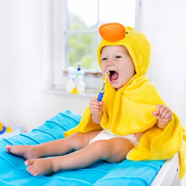 Bebé en toalla de baño con cepillo de dientes — Foto de Stock