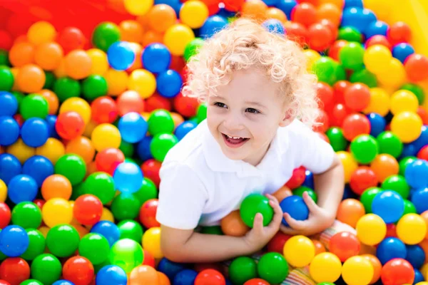 Niño jugando en el hoyo de la bola en el patio interior —  Fotos de Stock