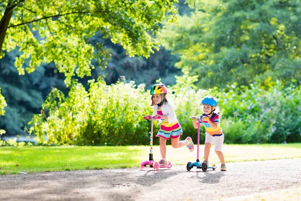 Kids riding scooter in summer park. — Stock Photo, Image