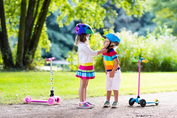 夏の公園でスクーターに乗る子供たち. — ストック写真