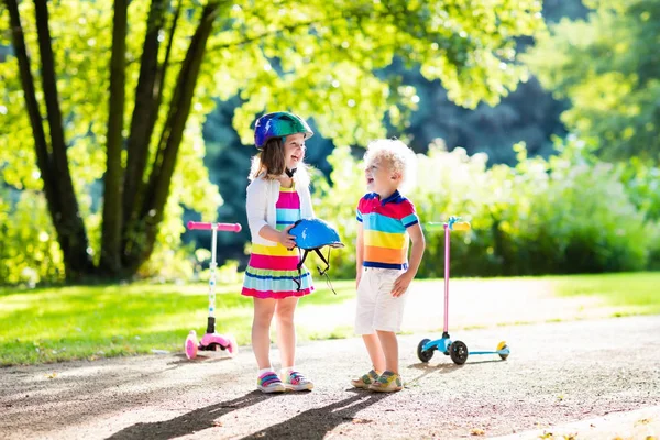 Barnen rider scooter i sommaren park. — Stockfoto