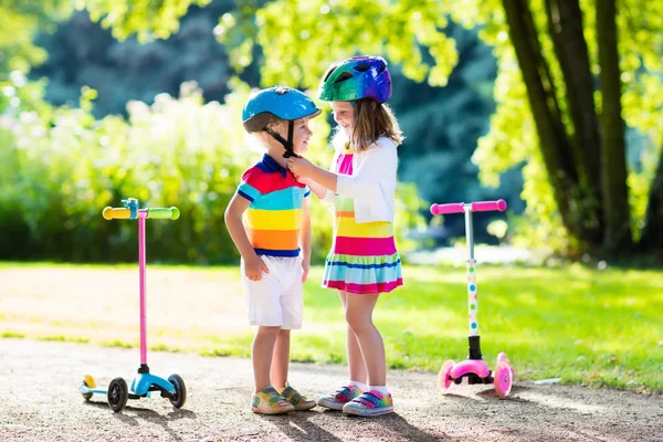 Barnen rider scooter i sommaren park. — Stockfoto