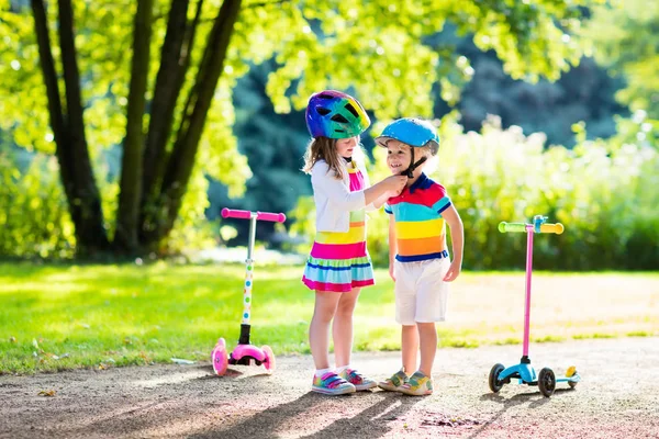 夏の公園でスクーターに乗る子供たち. — ストック写真