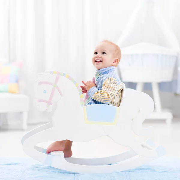 Menino em brinquedo de cavalo de balanço — Fotografia de Stock