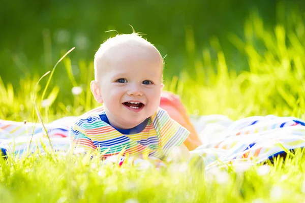 Baby boy with apple on family garden picnic — Stock Photo, Image