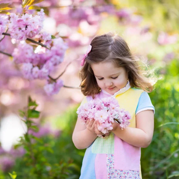 Liten flicka med körsbärsblommor — Stockfoto