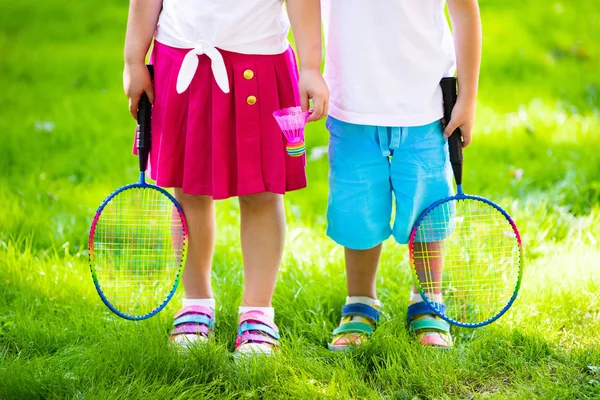 Děti hrají badminton nebo tenis na venkovní kurt — Stock fotografie
