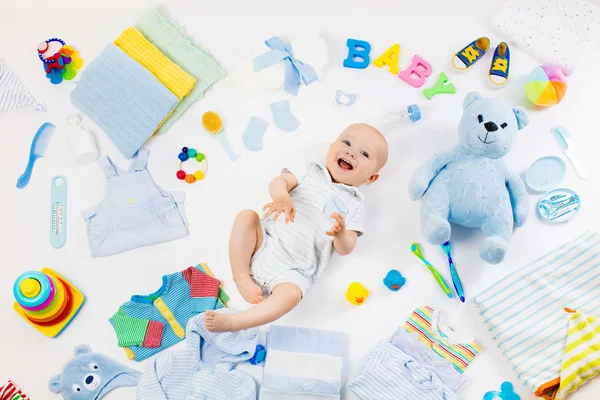 Baby with clothing and infant care items — Stock Photo, Image