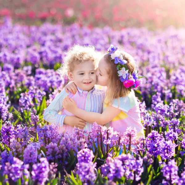 Дети играют в цветущем саду с гиацинтовыми цветами — стоковое фото