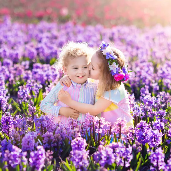 Kinder spielen im blühenden Garten mit Hyazinthenblüten — Stockfoto