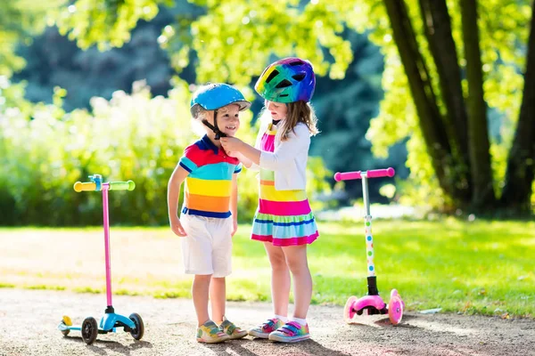 Barnen rider scooter i sommaren park. — Stockfoto