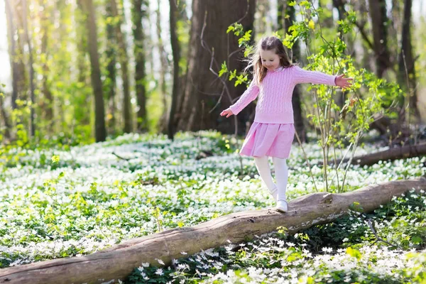 Child in spring park with flowers — Stock Photo, Image