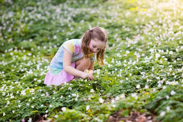 Niño en el parque de primavera con flores — Foto de Stock