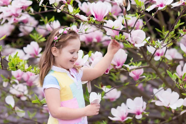 Kind mit Magnolienblüte. kleines Mädchen mit Blumen — Stockfoto