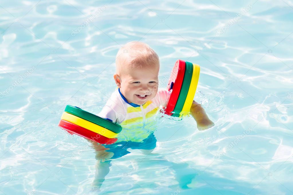 Little baby boy playing in swimming pool