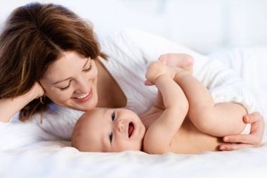Bebek ve anne evde yatakta. Anne ve çocuk.