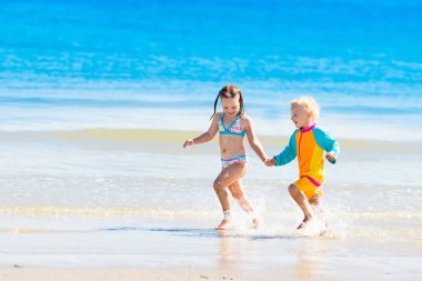 Çocuklar çalıştırmak ve tropik sahilde oynamak