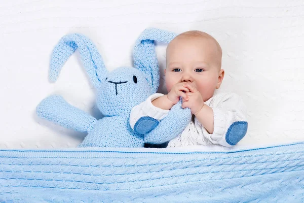 Bebé niño jugando con conejo juguete en la cama — Foto de Stock