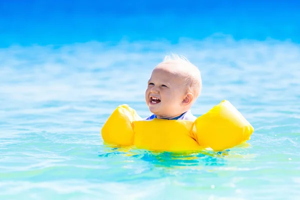 Baby swimming in ocean water on tropical beach — Stock Photo, Image