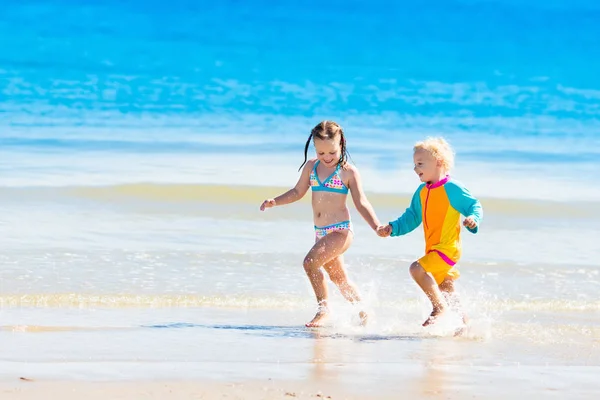 Kids run and play on tropical beach