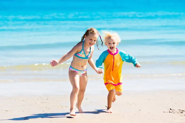 Los niños corren y juegan en la playa tropical —  Fotos de Stock