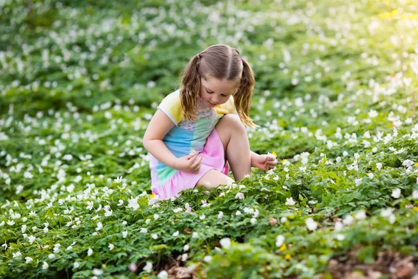 Criança no parque de primavera com flores — Fotografia de Stock