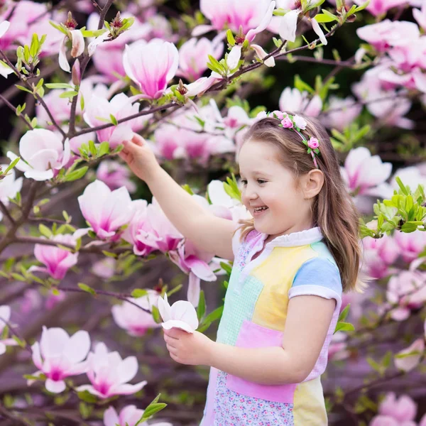 Kind mit Magnolienblüte. kleines Mädchen mit Blumen — Stockfoto