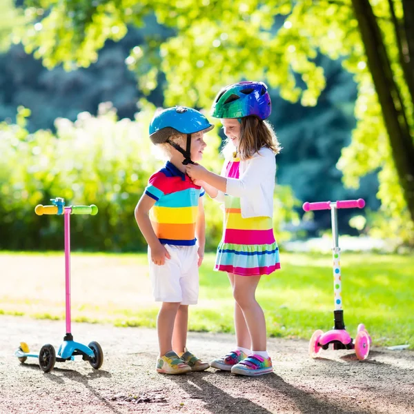 Kinderen rijden scooter in zomer park. — Stockfoto