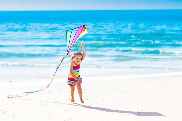 Kind fliegt Drachen am tropischen Strand — Stockfoto